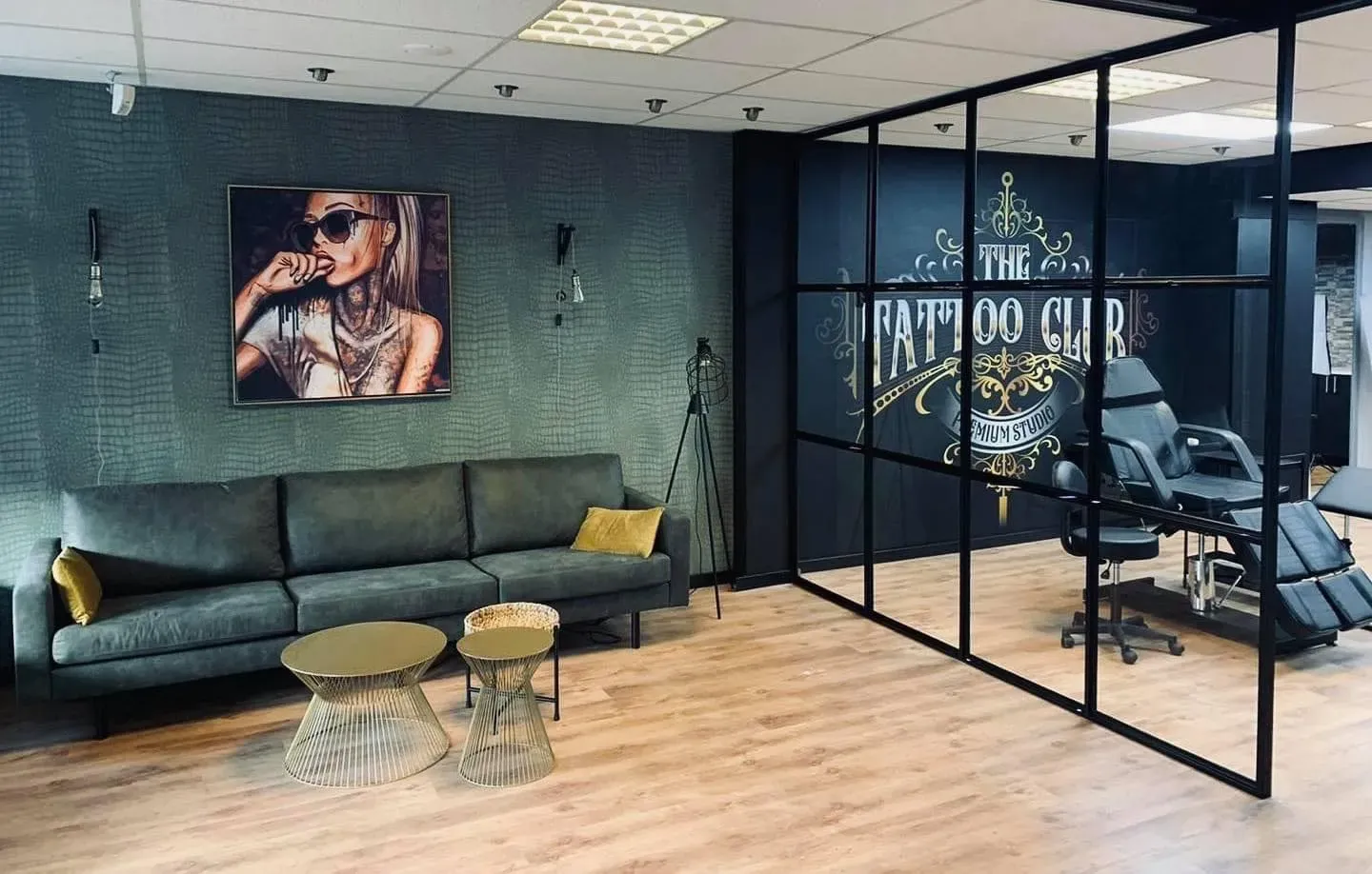 De studio aan de Molenweg: glazen wand met logo, tattoostoel en lounge